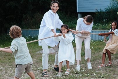Family playing tug of war in backyard, showcasing teamwork and joy.